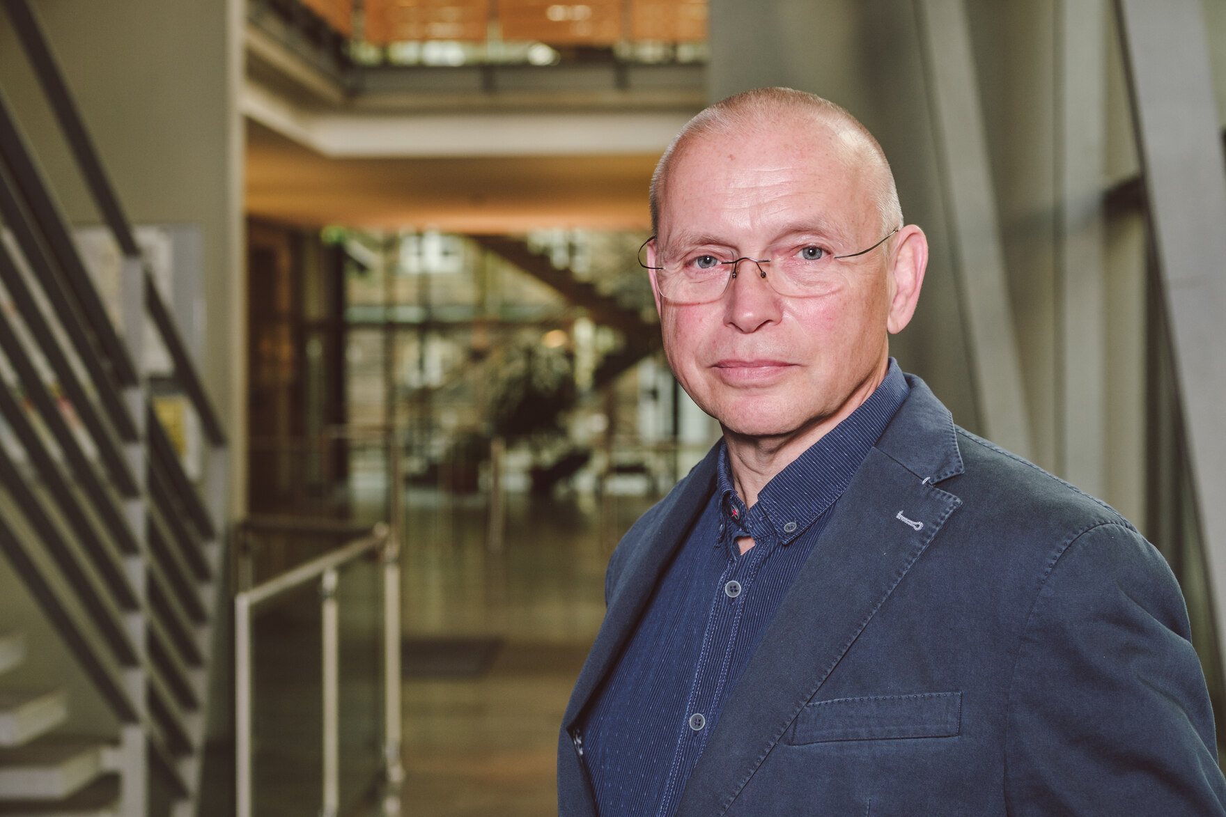 Torsten Kosuch im Foyer des SMI, mit dunkelblauem Jacket und blauem Hemd