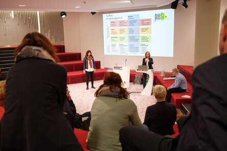 zeigt Andrea Carl und Renate Schwarz-Saage am Rednerpult beim Vortrag am 6. Landespräventionstag