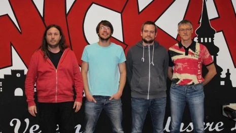 vier Personen vor einer Graffiti-Wand des Fanprojekts Zwickau.