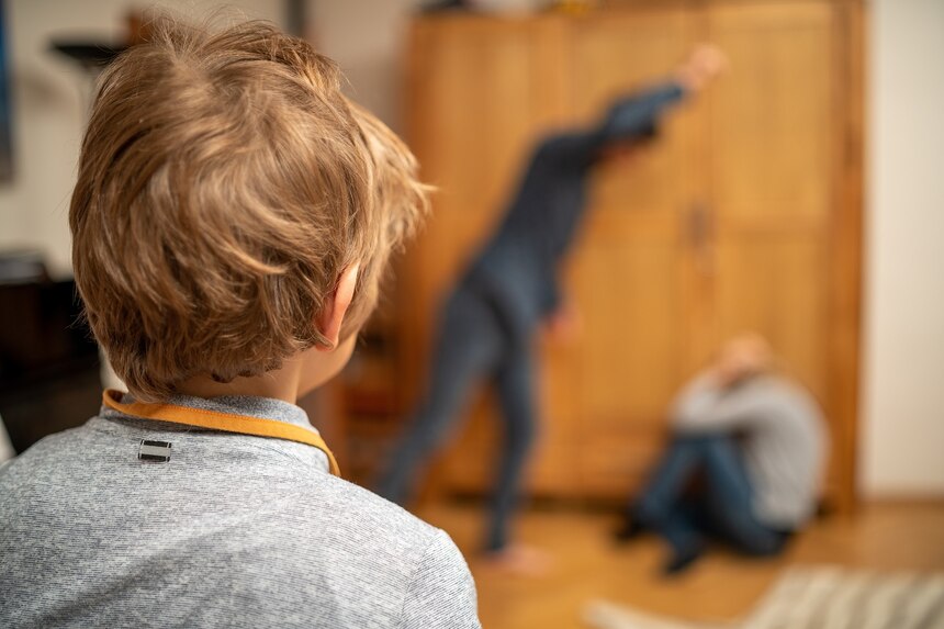 Nachstellung häusliche Gewalt, Mann der Frau schlägt und Kind sieht es aus der Ferne