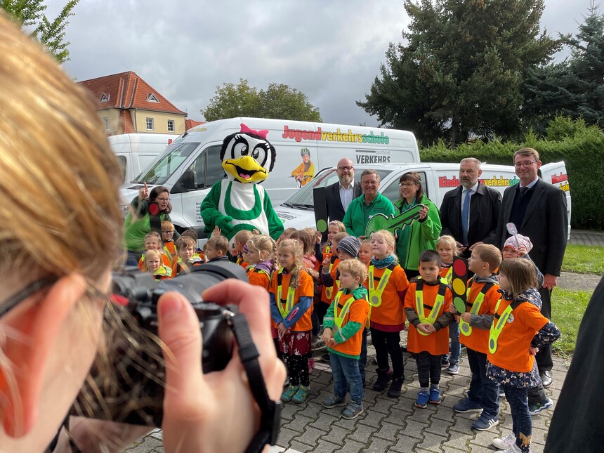 Übergabe der Verkehrsschulen für Schüler mit einer Fotografin im Vordergrund