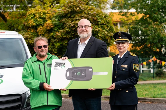Kollegen der Landesverkehrswacht, der Präsident und die Inspekteurin der Polizei halten feierlich und symbolisch den Autoschlüssel in der Hand.