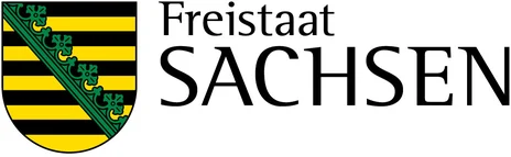 Auf dem Bild sieht man das Landeswappen. Der Schild des sächsischen Wappens wird neun Mal von Schwarz und Gold geteilt. Ein aus Sicht des Betrachters von links oben nach rechts unten verlaufender grüner Rautenkranz teilt den Schild.