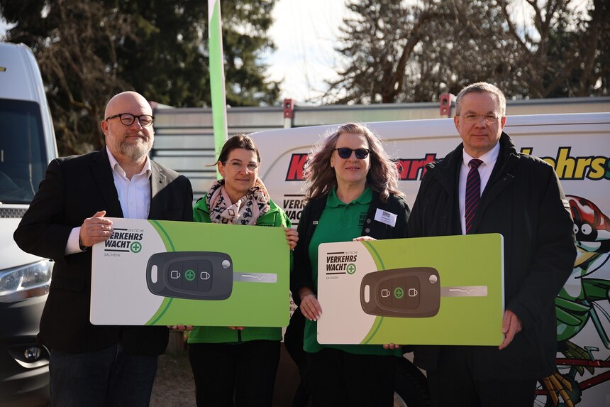 Personen halten symbolisch einen Autoschlüssel für die Jugendverkehrsschulen in der Hand
