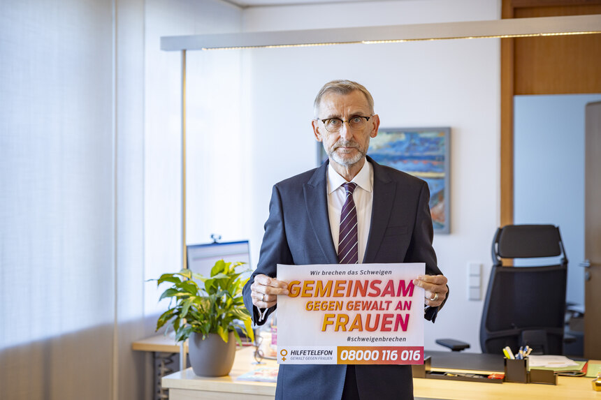 Bild zeigt Staatsminister des Innern, Sachsen mit einem Blatt in der Hand mit der Aufschrift »Wir brechen das Schweigen, Gemeinsam gegen Gewalt an Frauen«